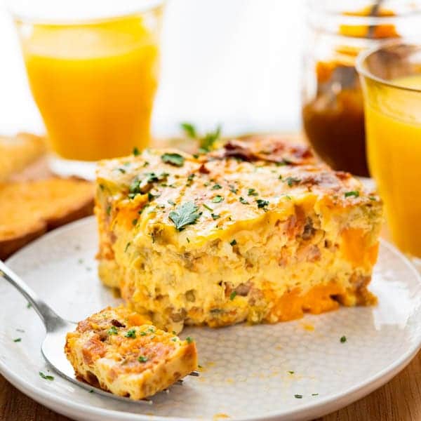 Chorizo Egg Bake on a plate with orange juice and other breakfast fixings.