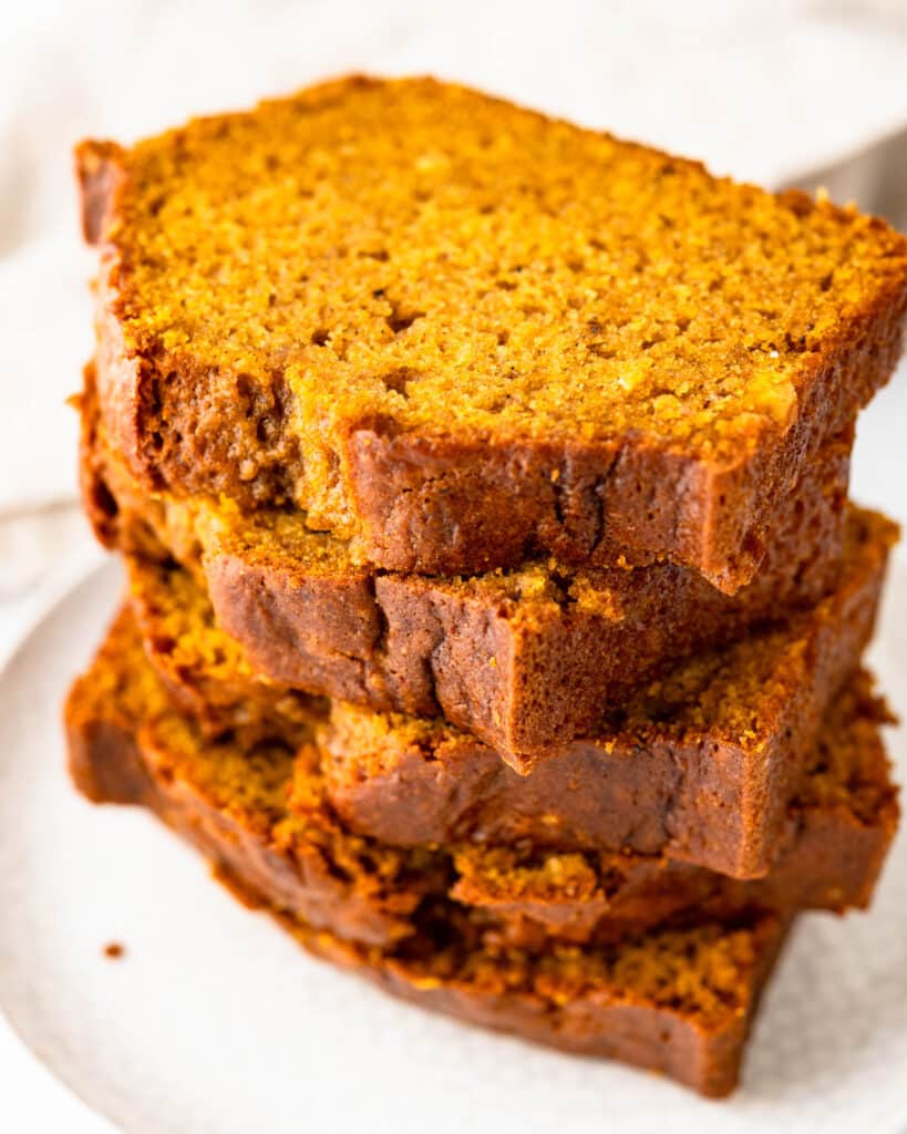 A stack of sliced pumpkin bread on a plate.