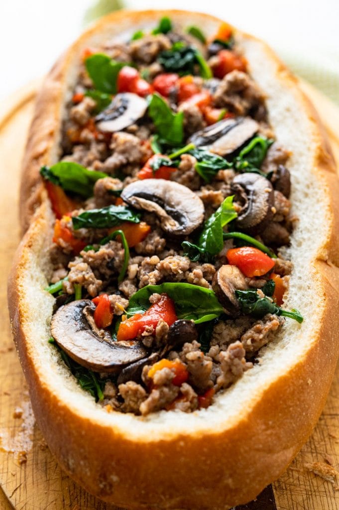 stuffing the bread with sausage, spinach, mushrooms and peppers.