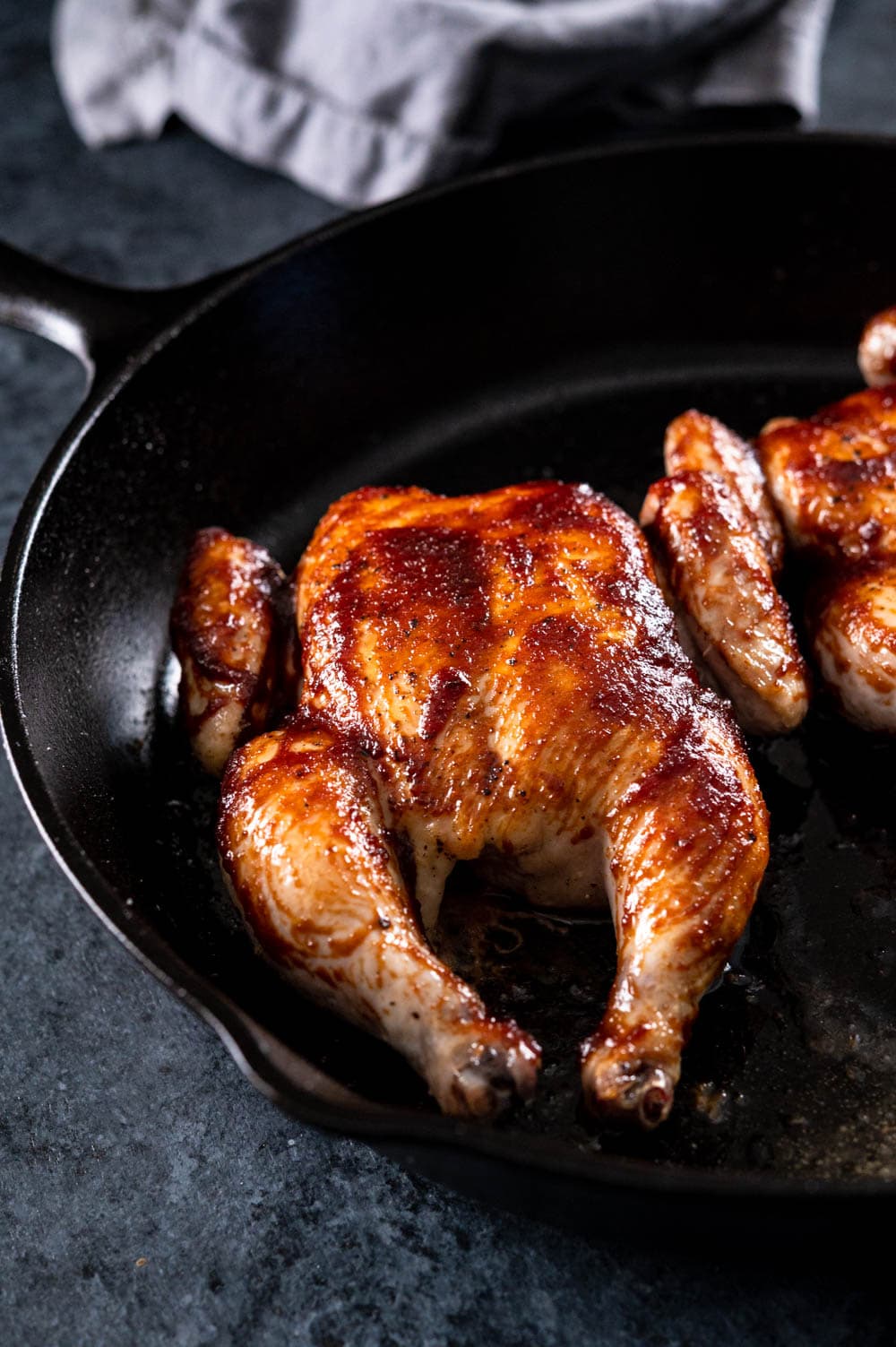 Poussins with bbq sauce in a cast iron skillet.