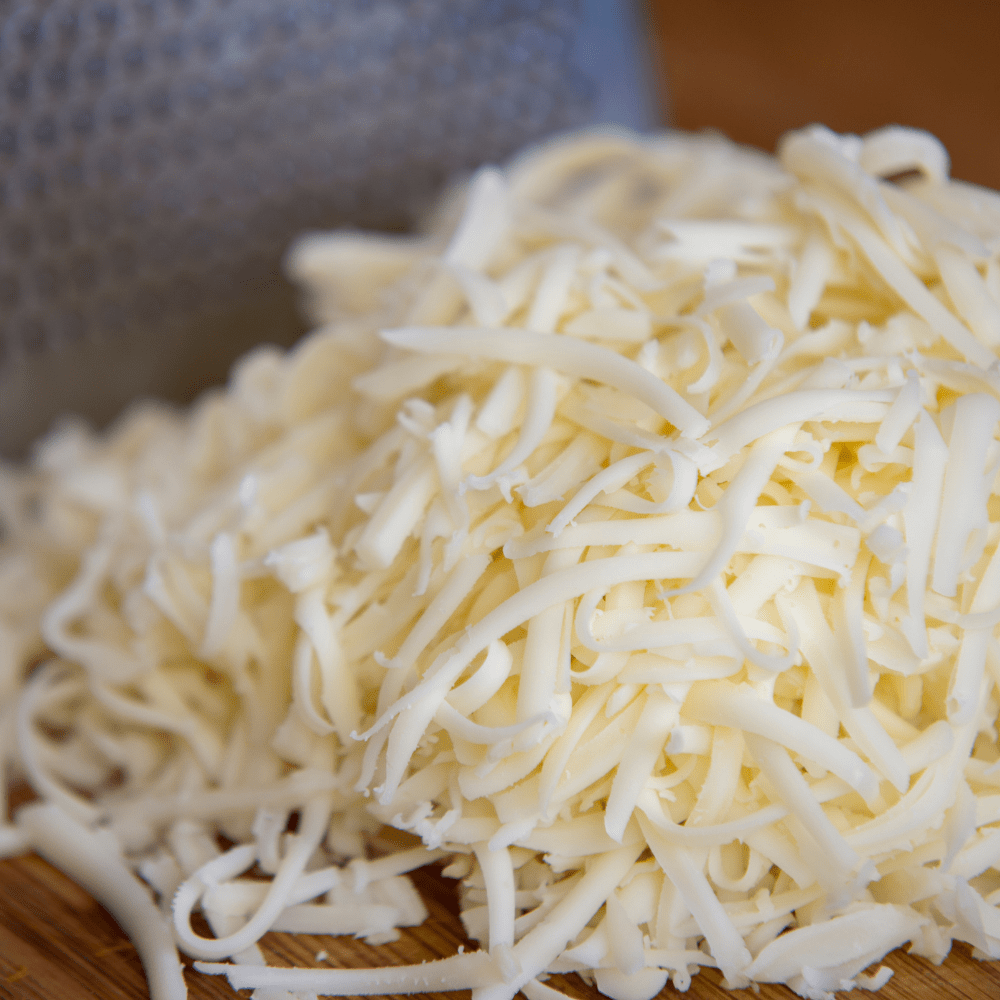 grated cheese on a cutting board.