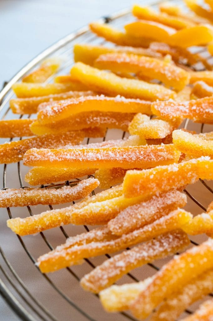 sugaring the candied citrus peel and setting it to dry on a rack.