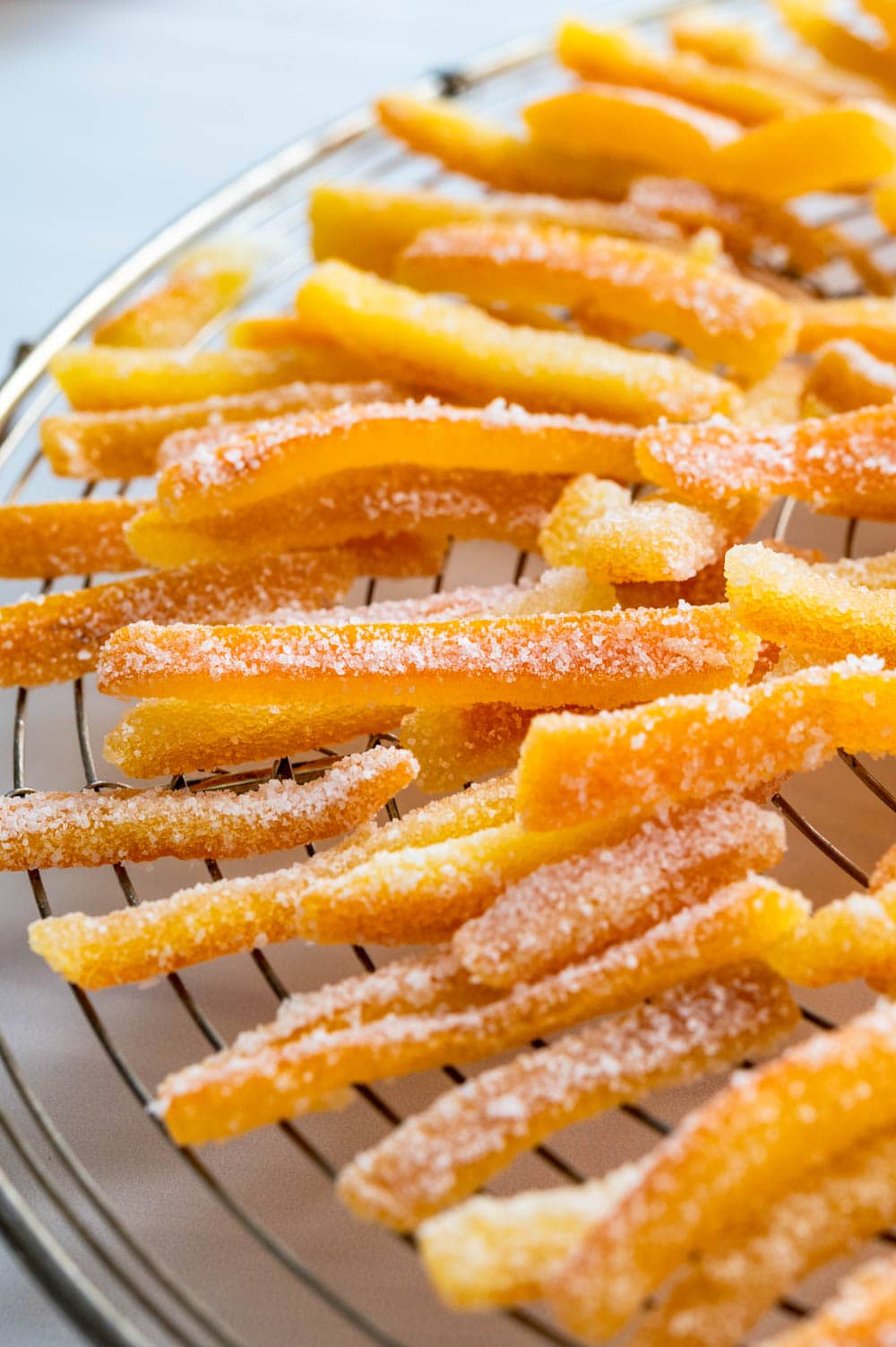 sugaring the candied citrus peel and setting it to dry on a rack.