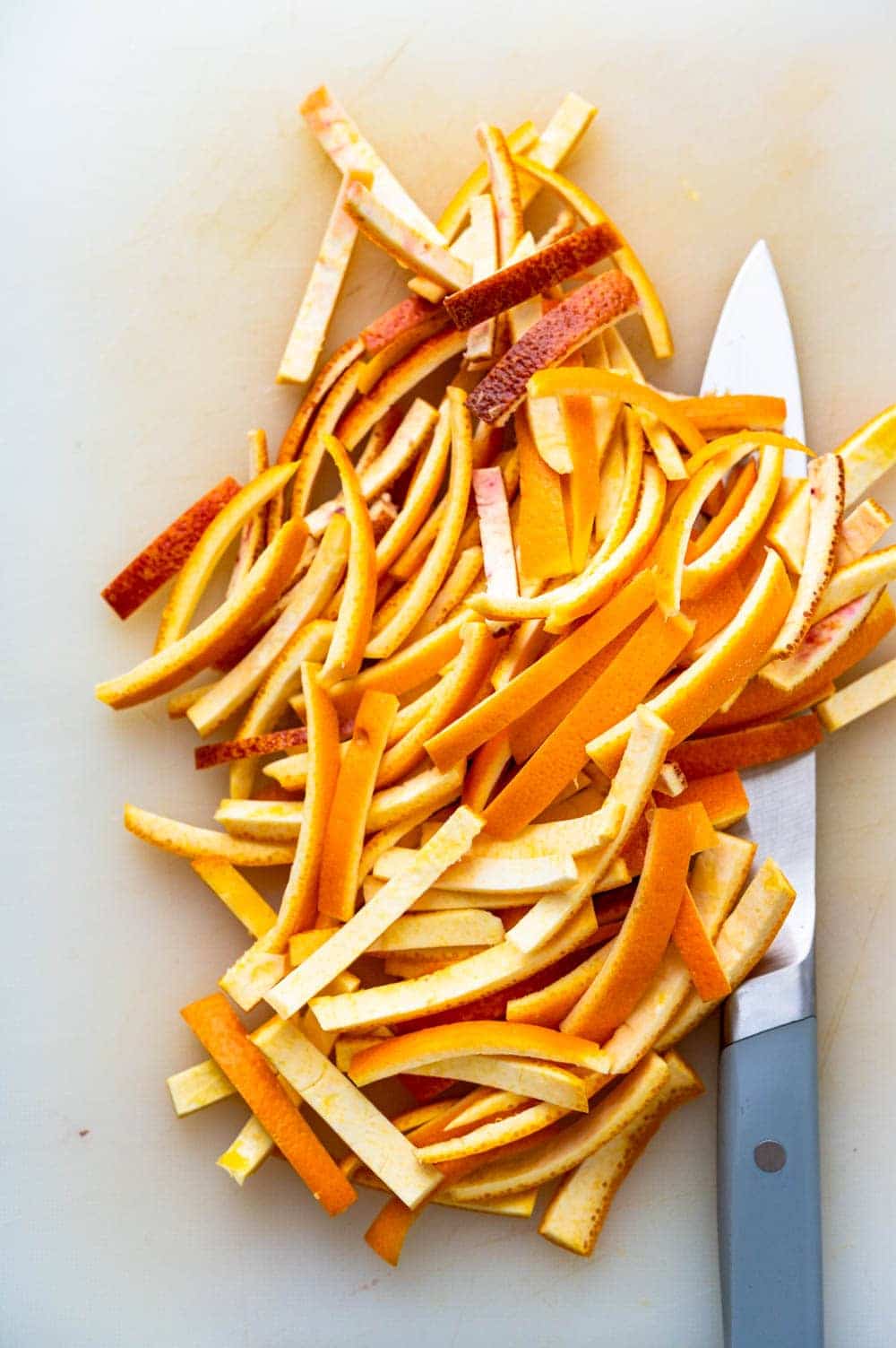 slicing citrus peels into thin strips for blanching.