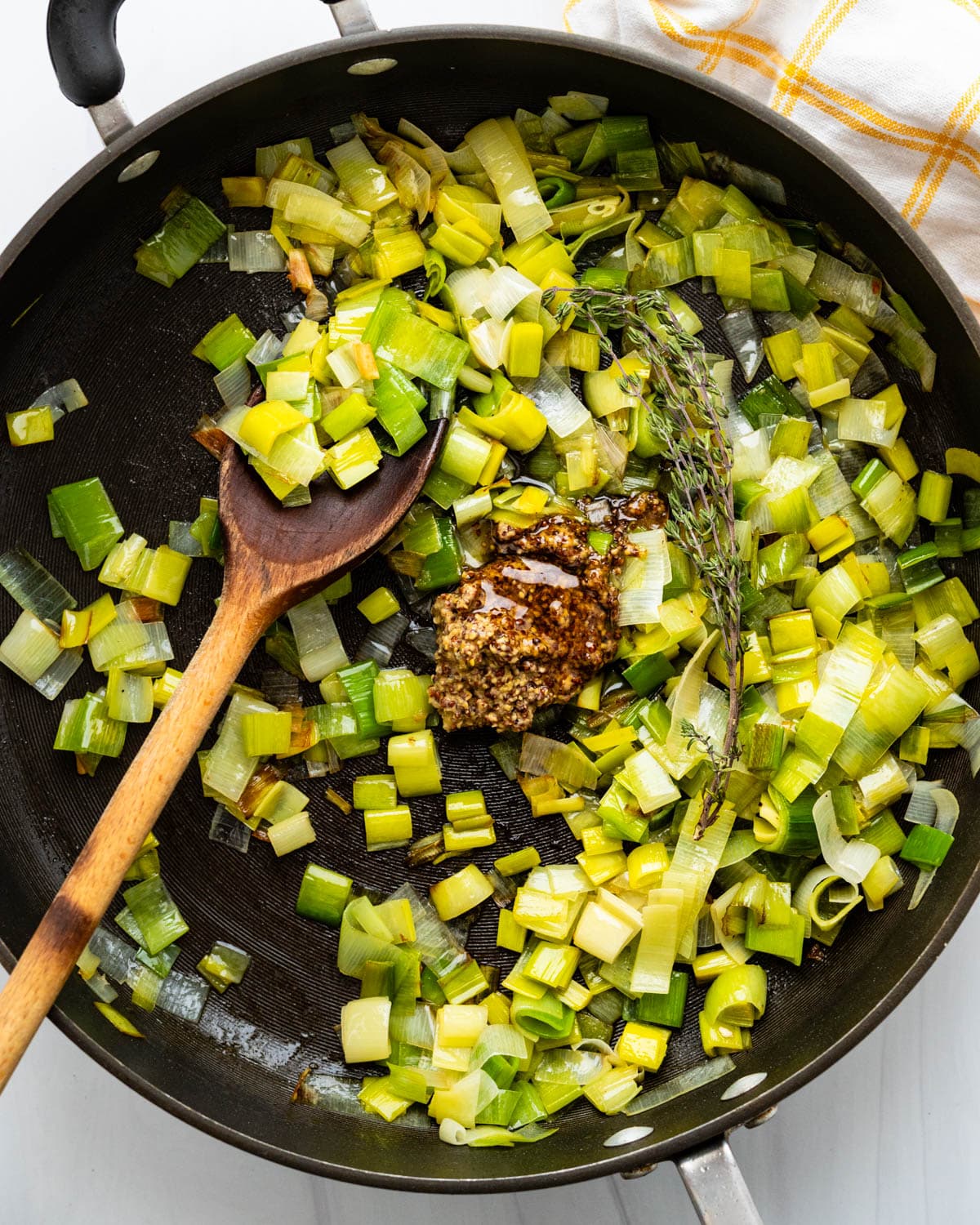 Sweat the leeks and add whole grain Dijon mustard, honey, and thyme.