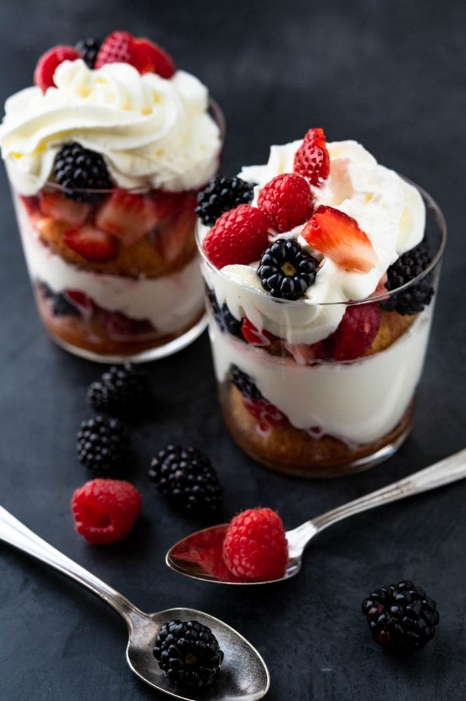Berry Parfaits a simple dessert for two with spoons on a black background.