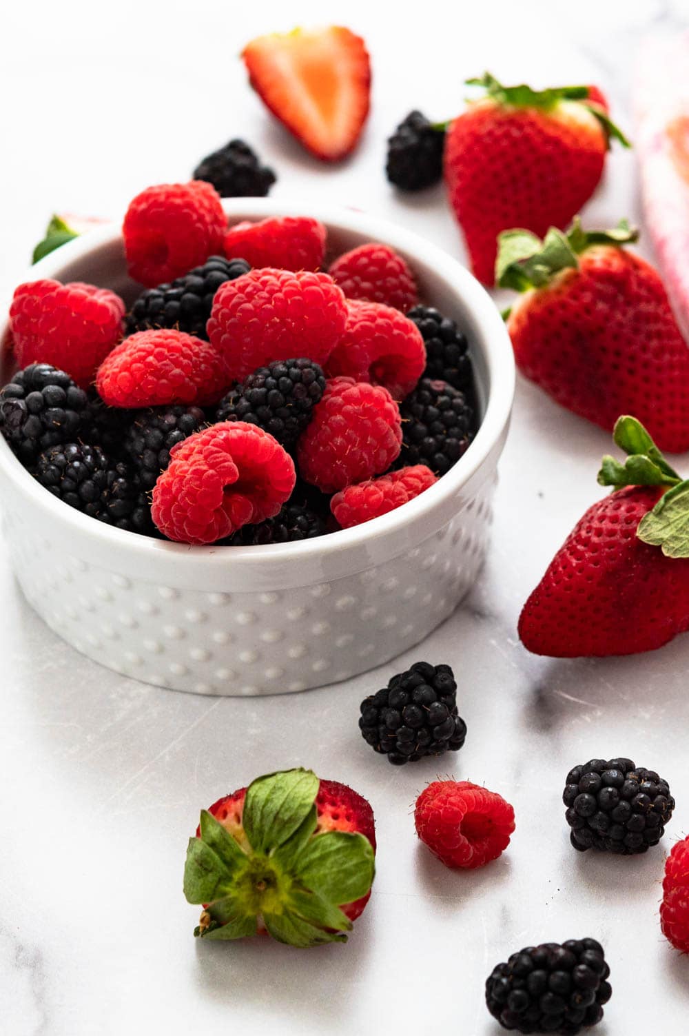 a bowl of raspberries, blackberries and strawberries.