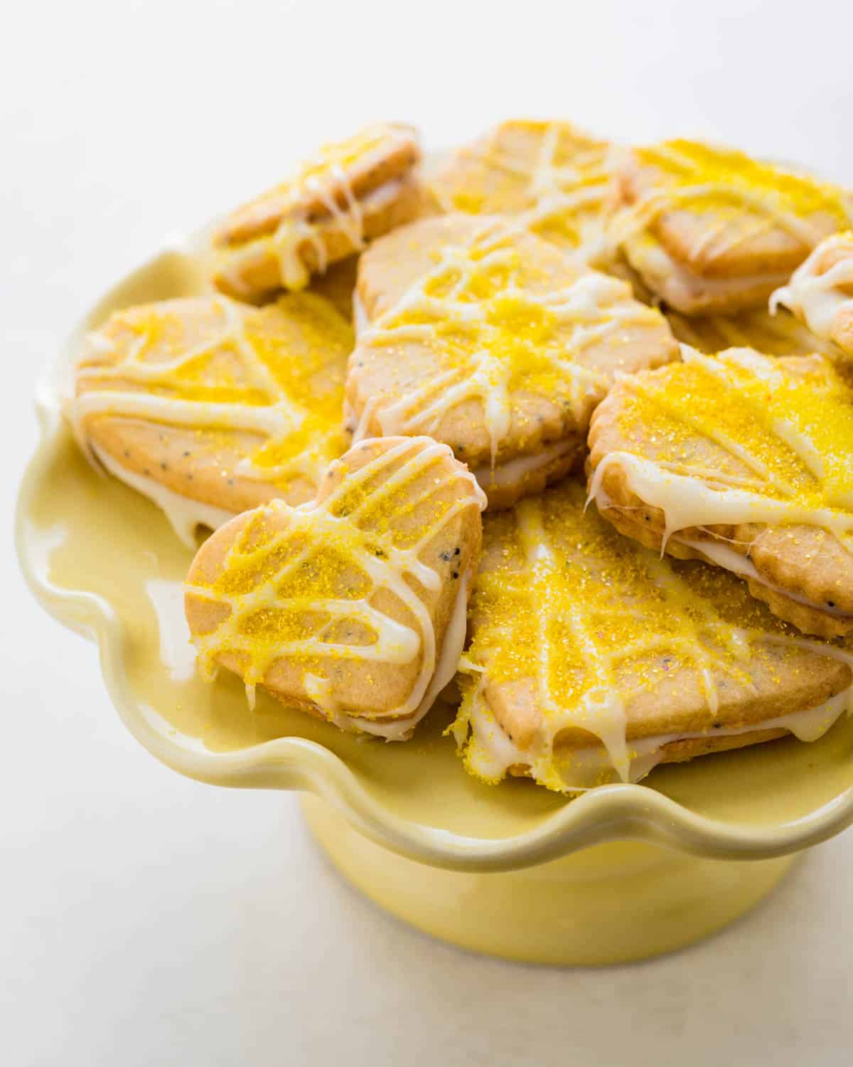 a yellow pedestal filled with lemon heart sandwich cookies.
