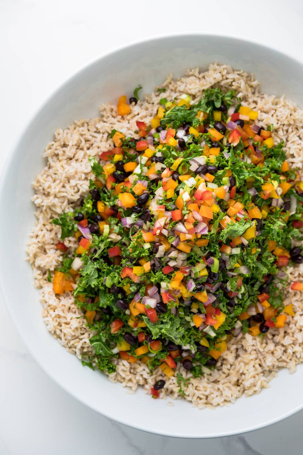 combining chopped veggies with cooked brown rice.