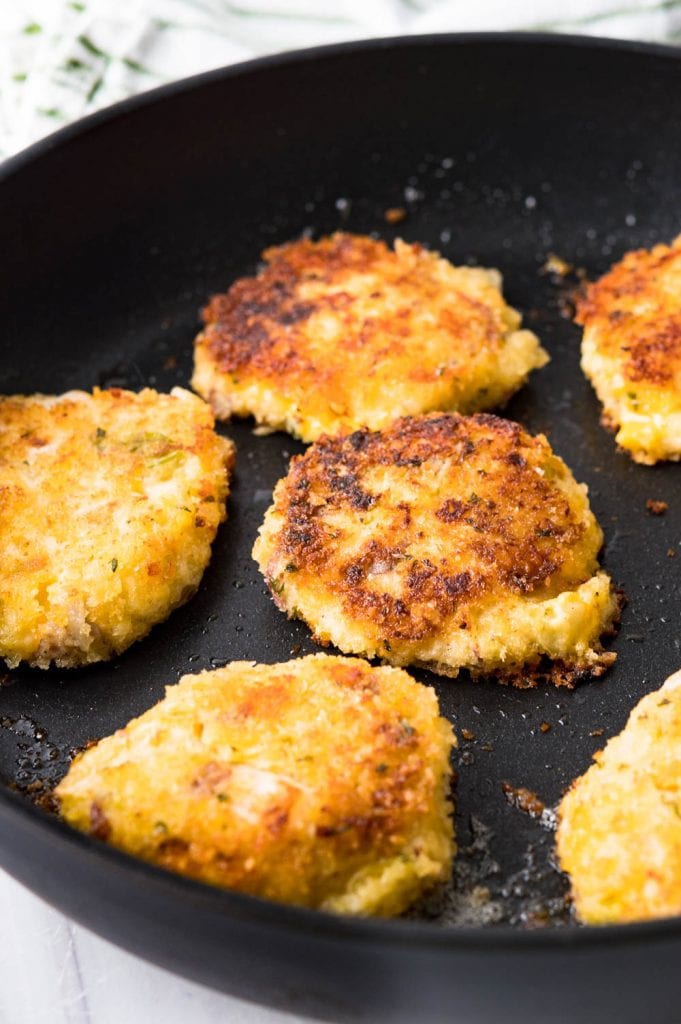 fried mashed potato patties in a hot skillet.