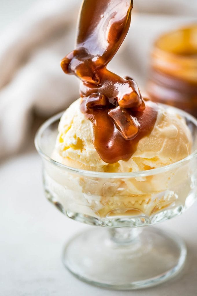 topping a dish of ice cream with bourbon pecan caramel sauce. 
