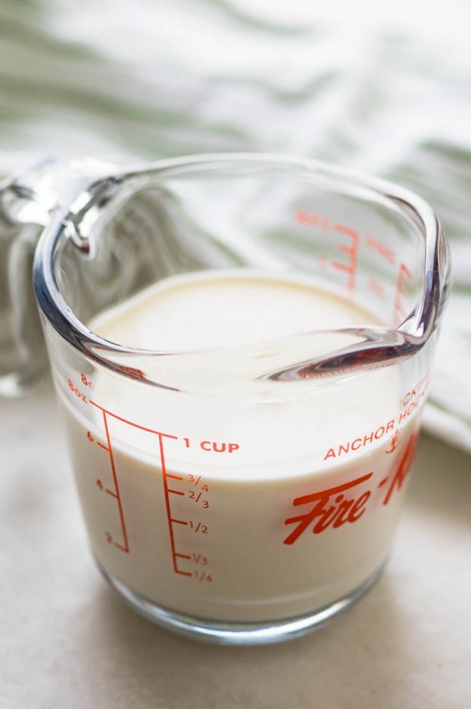 a glass measuring cup with heavy cream. 