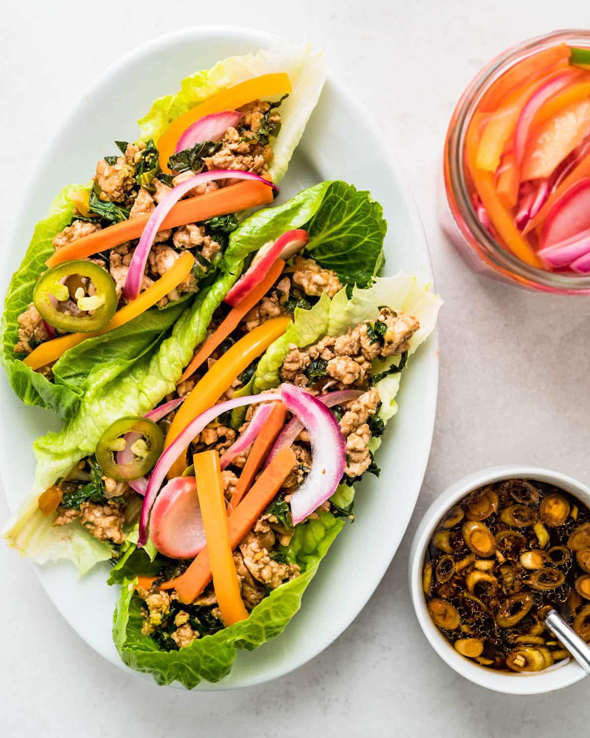 turkey lettuce wraps with sauce and pickled veggies.