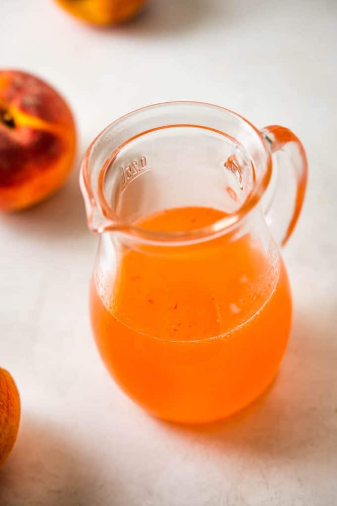 a pitcher of peach simple syrup.