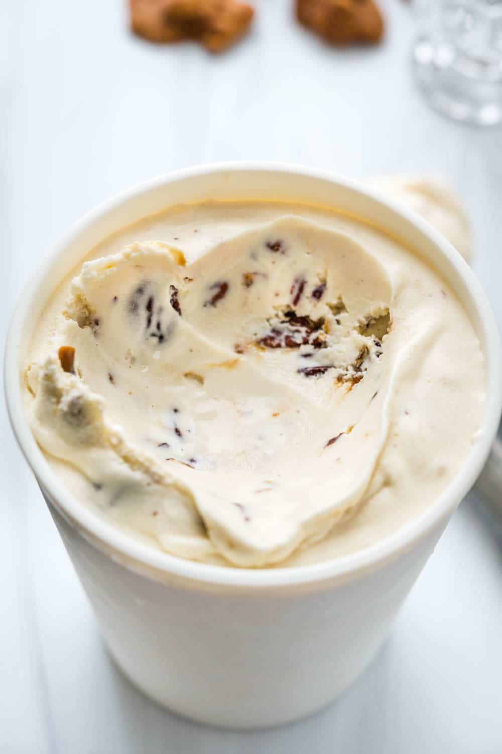 a container of bourbon pralines and cream ice cream with a scoop missing.