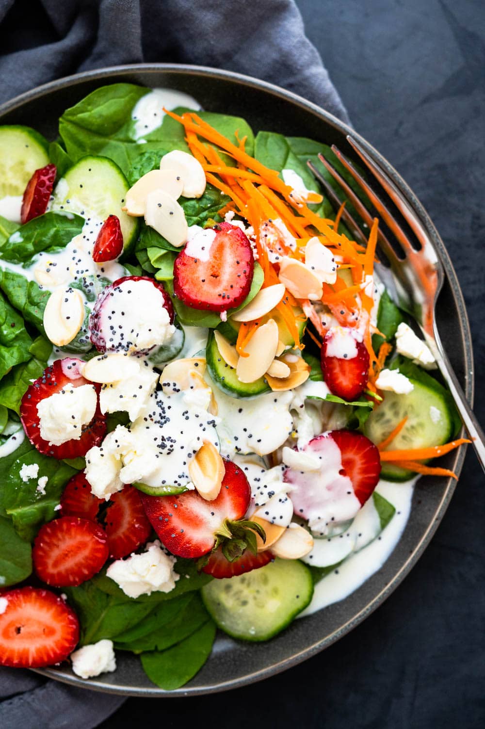an overhead shot of the summer strawberry salad on a plate with dressing.