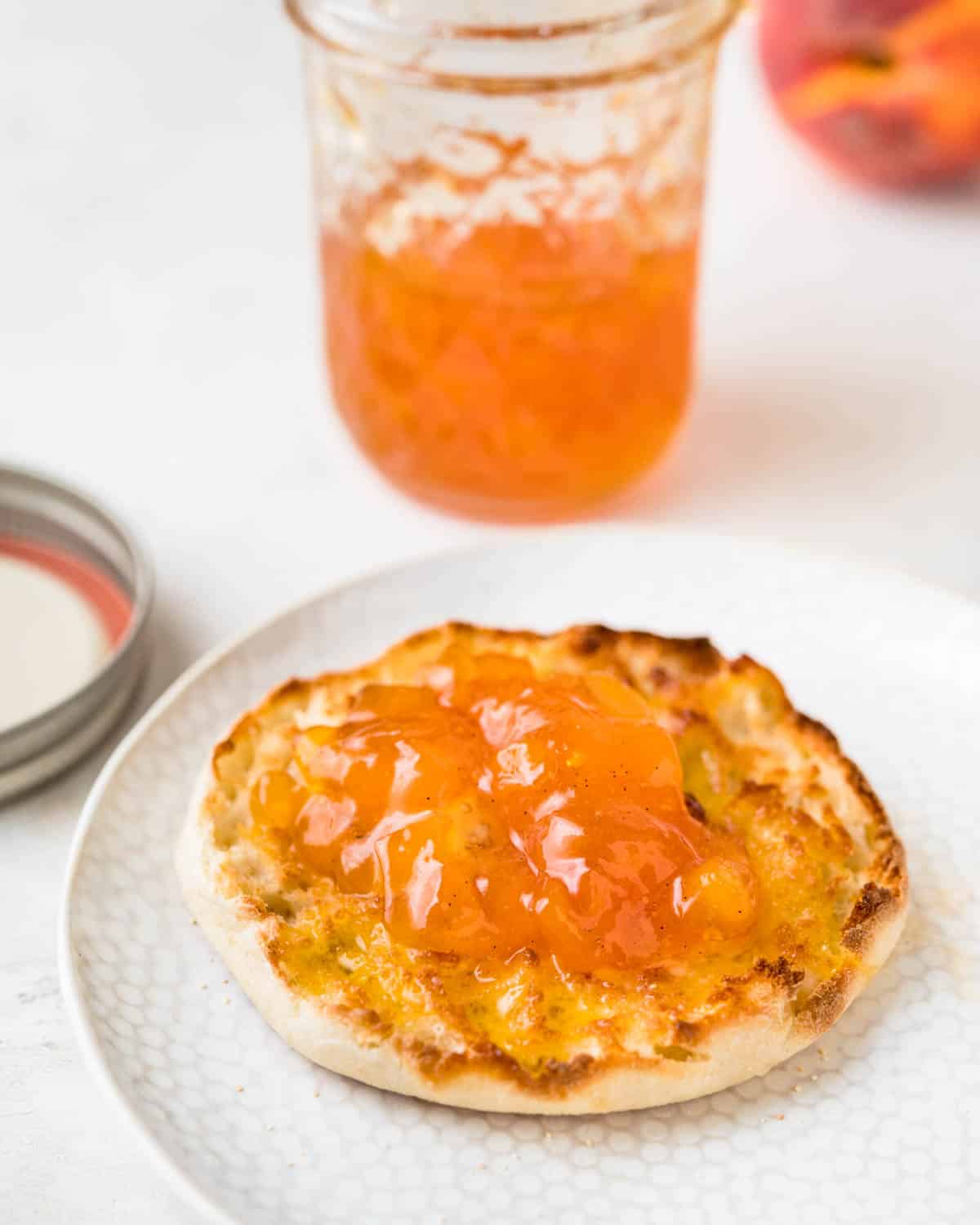 An english muffin topped with peach jam.