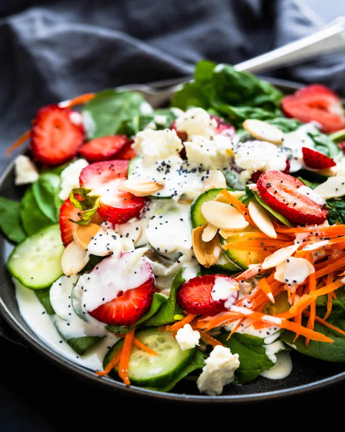 A serving of strawberry spinach salad with poppyseed dressing.
