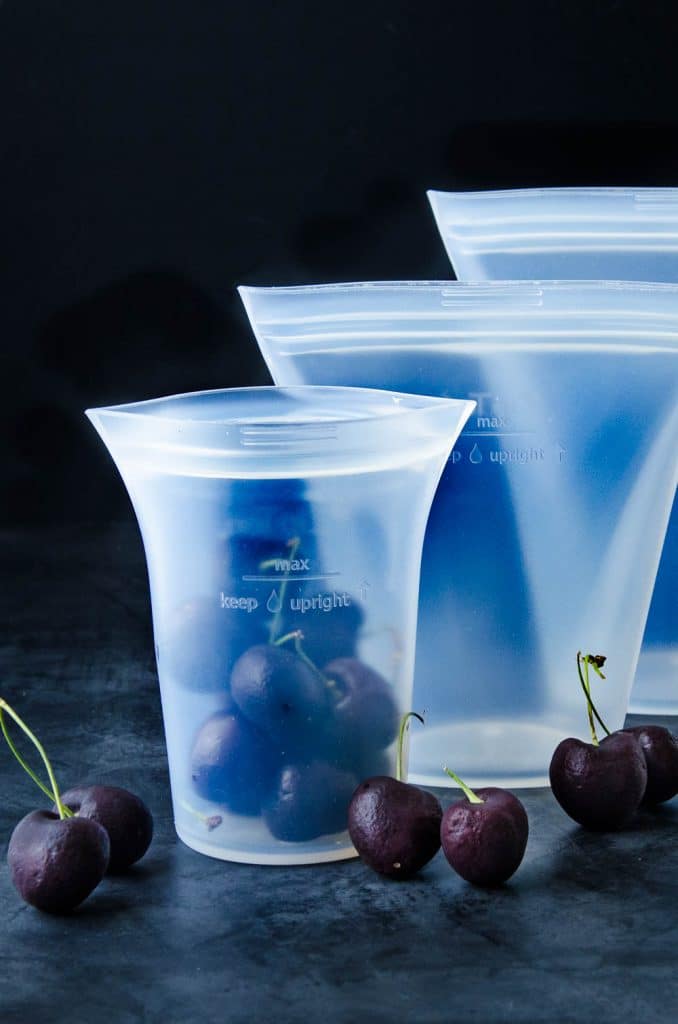 cup containers in three sizes. One cup filled with cherries.