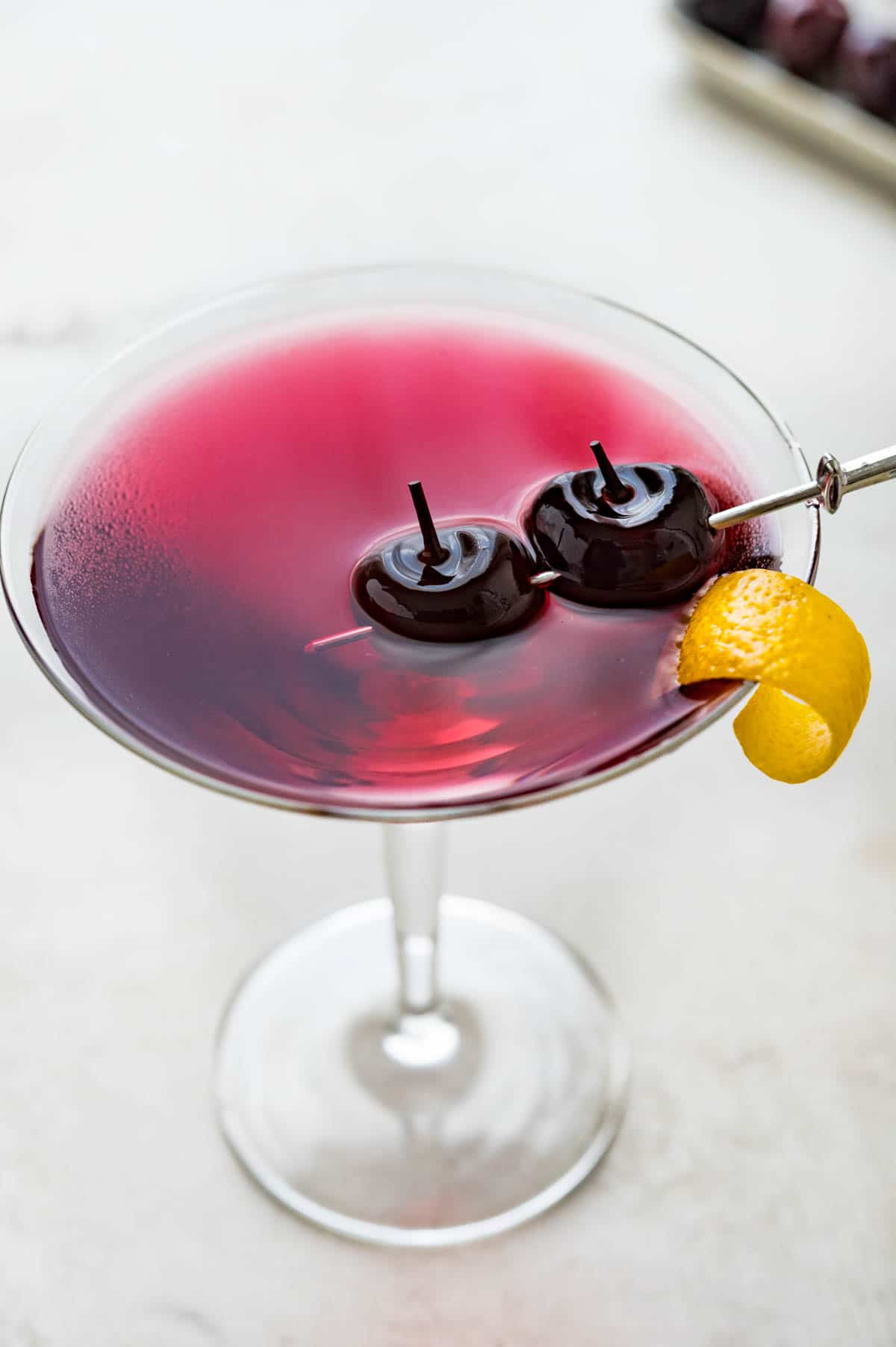 a luminescent cherry red martini with garnish.