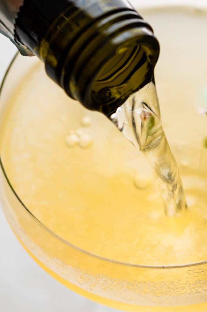 adding prosecco to the cucumber melon cocktail.