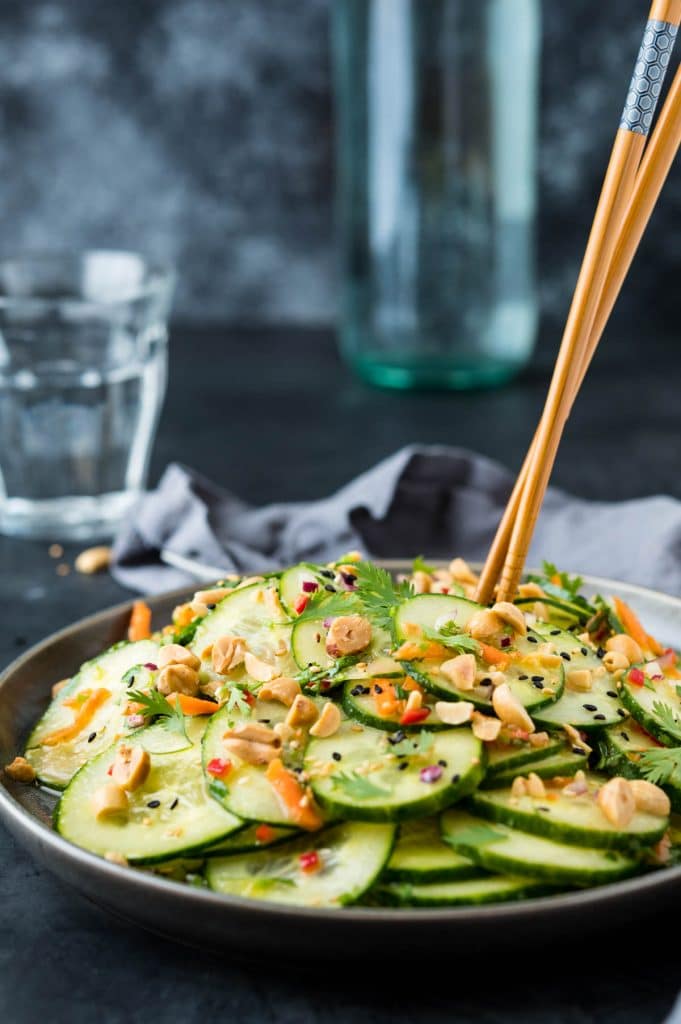 Asian Cucumber Salad on a plate with chopsticks.