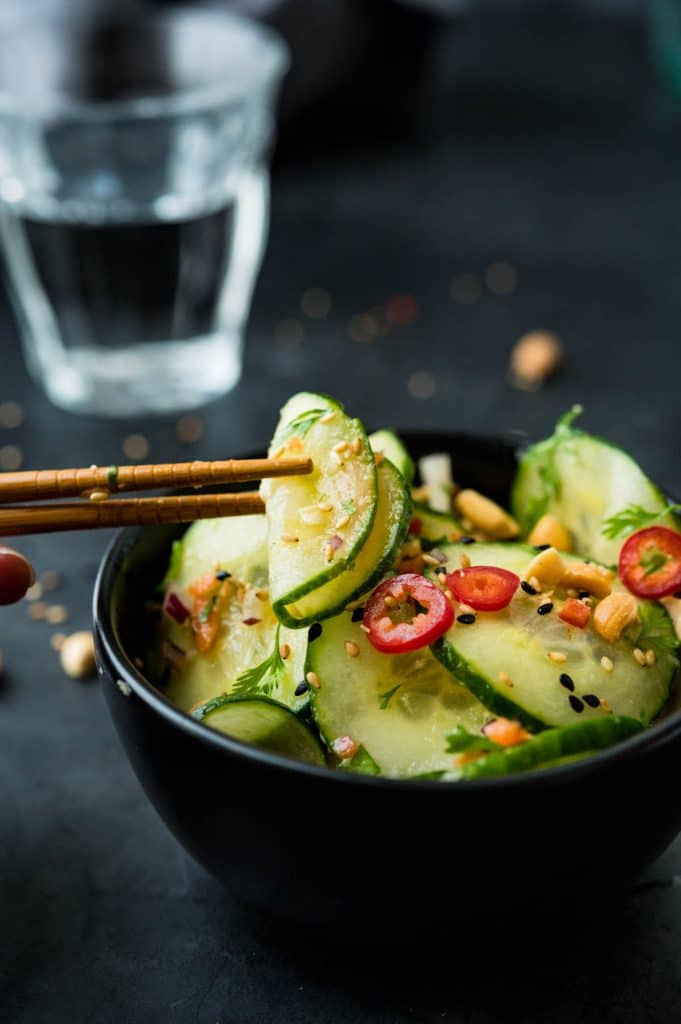 Serving cucumber salad in a small bowl with chopsticks.