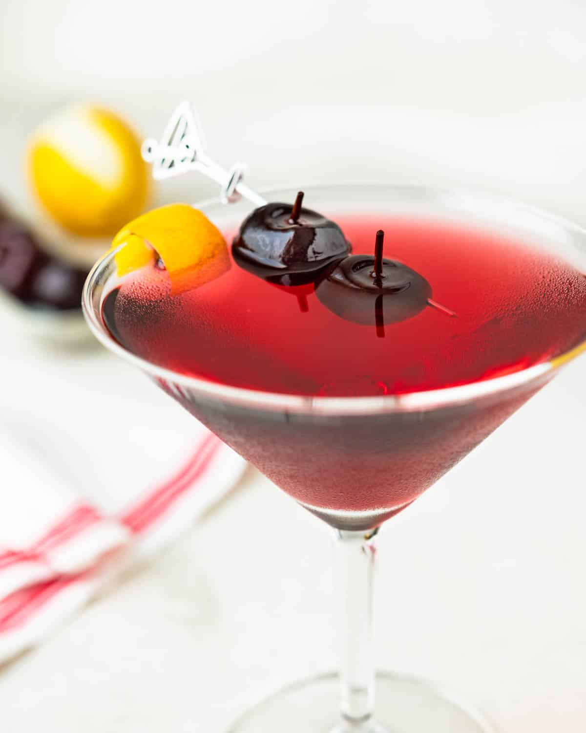 A cherry martini in a glass with garnish.