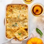 a hearty butternut squash lasagna with a serving being cut.