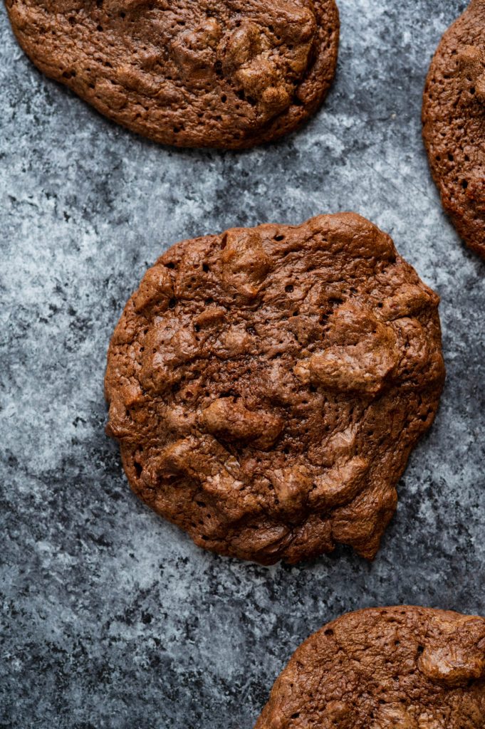 closeup of the dark chocolate cookies on a gray backboard.