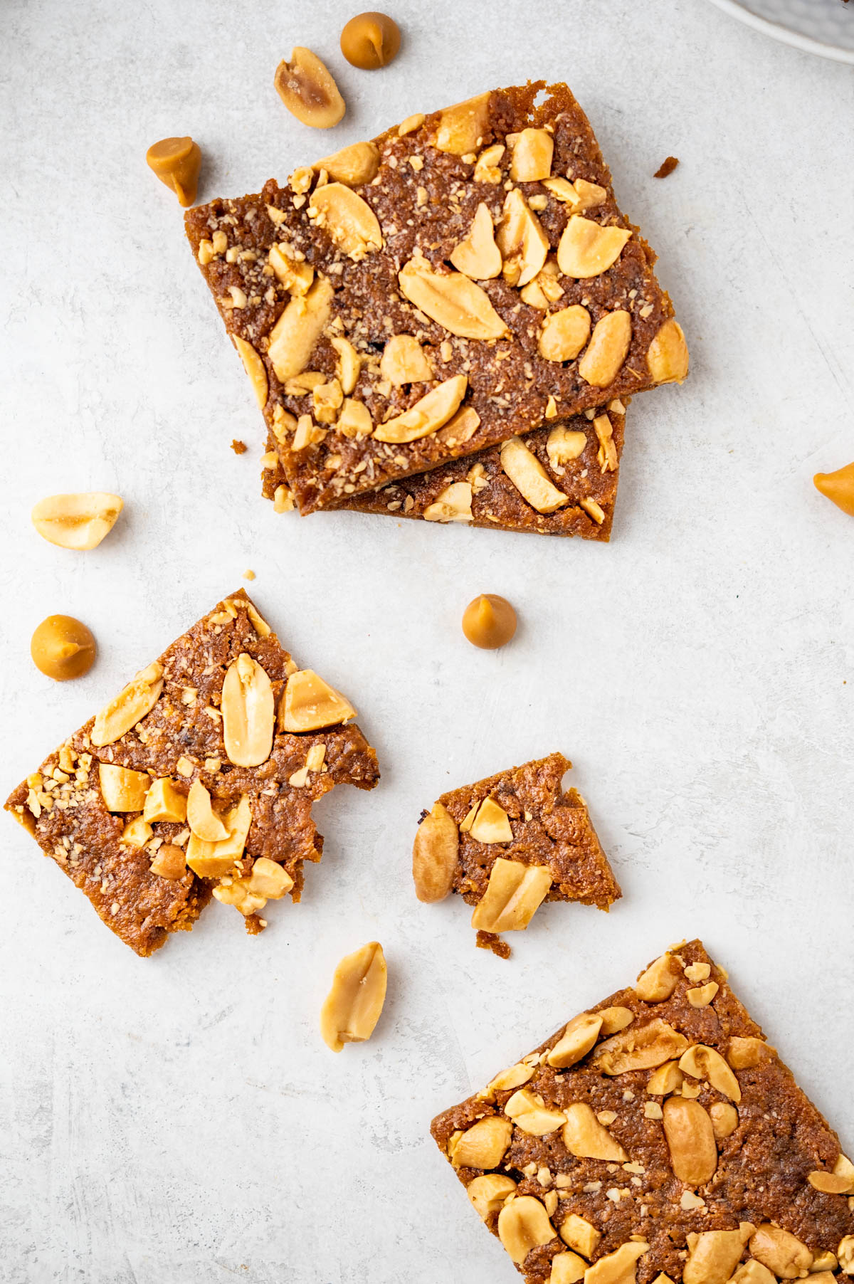 crunchy peanut bars with extra peanuts and butterscotch morsels on a counter. 