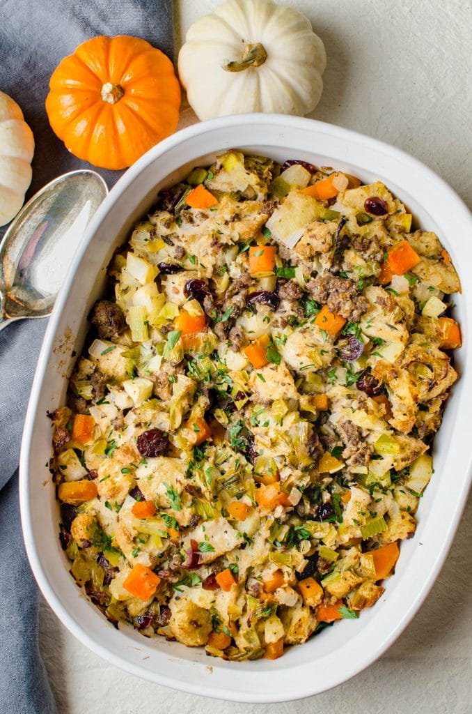 A casserole of stuffing with pumpkins surrounding.