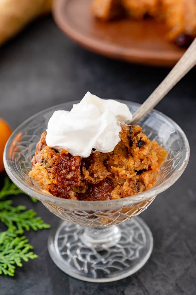 a bowl of persimmon pudding with whipped cream.