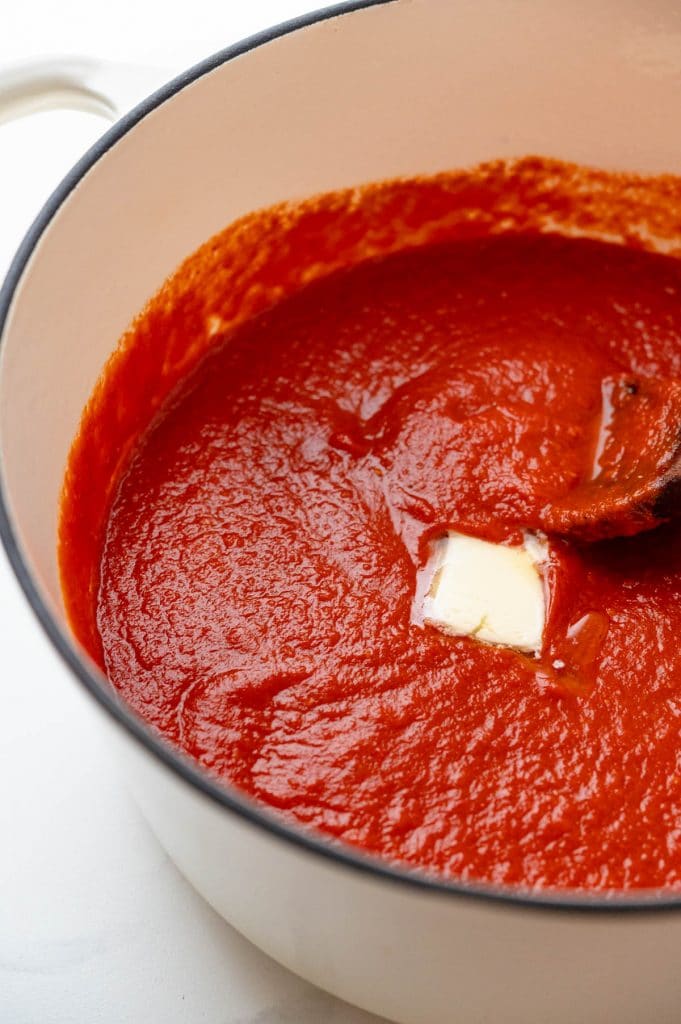 swirling butter into the fresh spaghetti sauce.