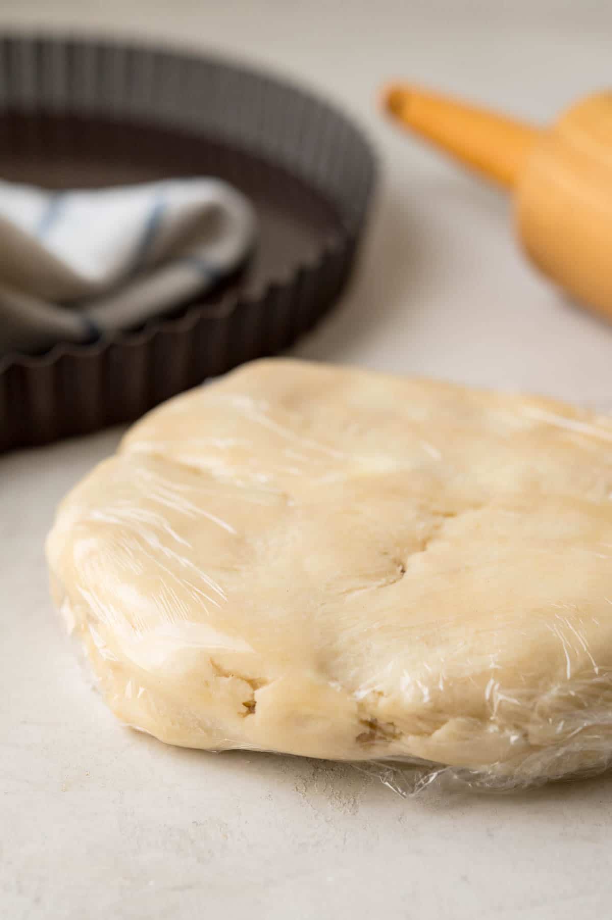 A recipe of cream cheese pie crust for mini pies and quiches wrapped in plastic.
