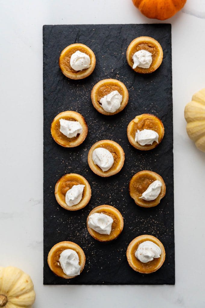mini pumpkin tarts garnished with whipped cream and nutmeg. 