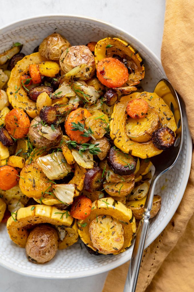 an overhead shot of the roasted root vegetables with a serving spoon.