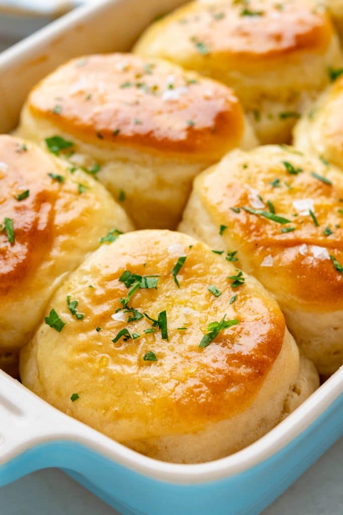 Freshly baked and garnished refrigerator rolls in a baking dish.
