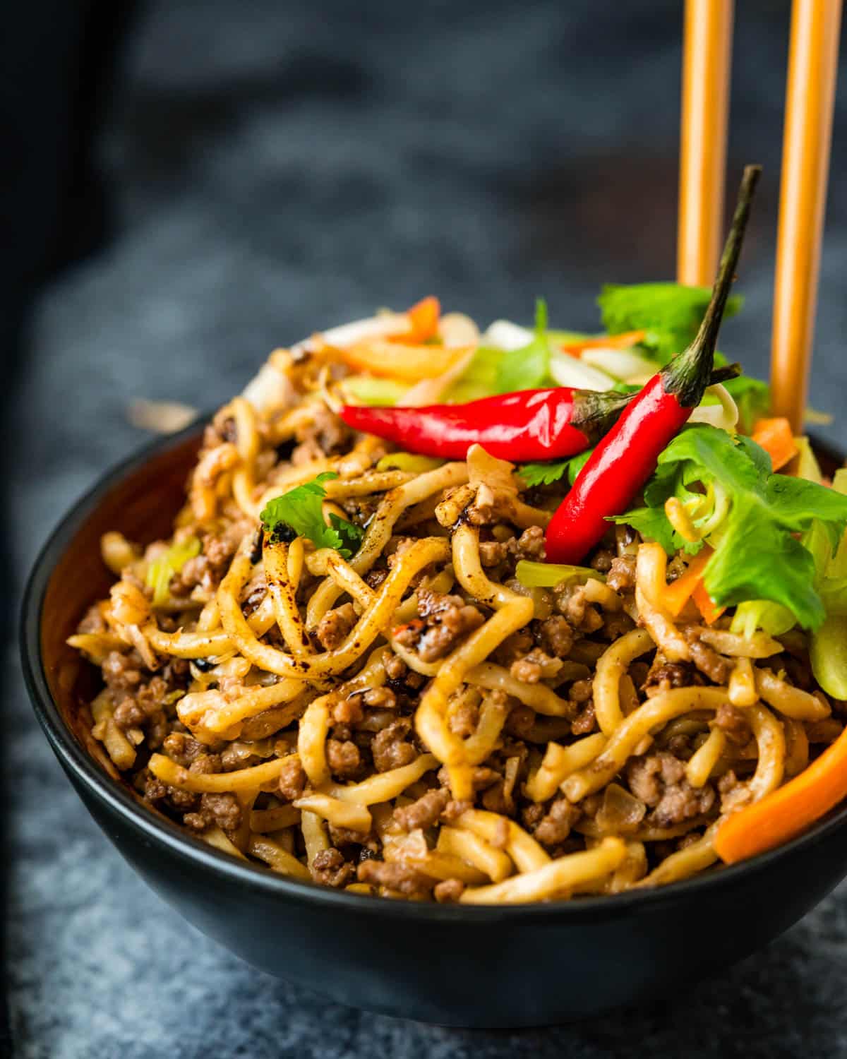 Chinese beef noodles in a bowl with chopsticks.