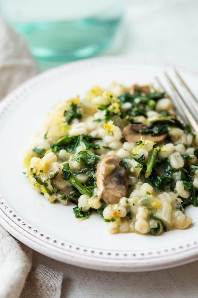 Serving the kale barley and mushroom casserole on a plate. 