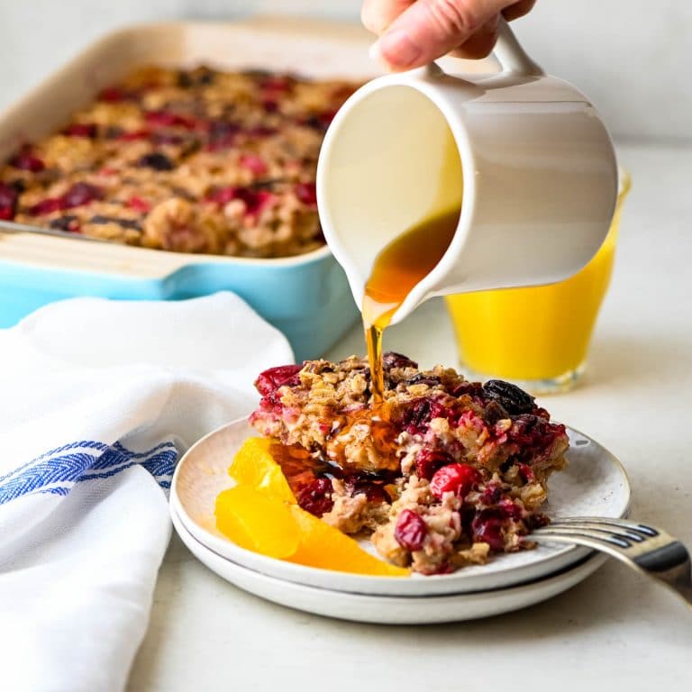 baked oatmeal with maple syrup being drizzled over it.