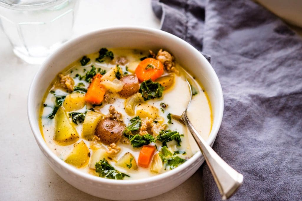 serving a bowl of sausage kale and potato soup in a bowl. 