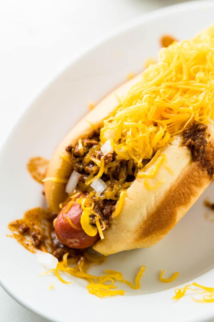 Serve the Cincinnati Chili Dog on an oval plate to catch all the excess.