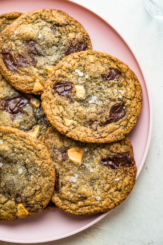 a pink plate loaded with salted chocolate chunk cookies.