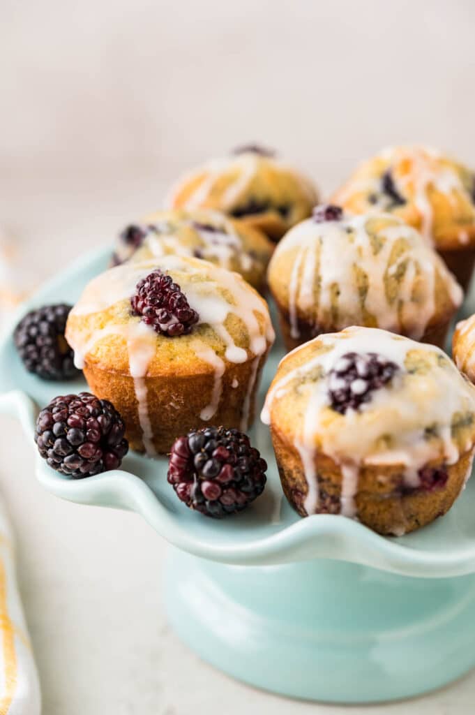 Glazed Lemon blackberry muffins arranged on a cake plate to serve.