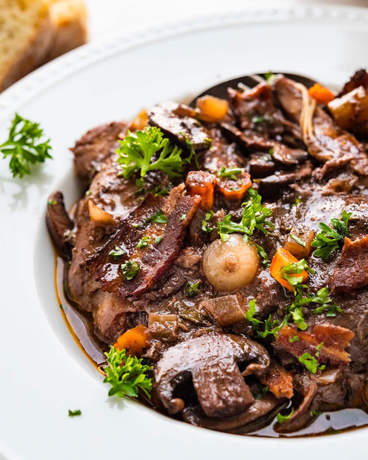 A dish of coq au vin with pearl onions and bacon.