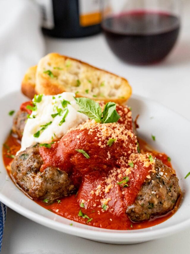 meatballs and marinara on a plate with ricotta cheese.