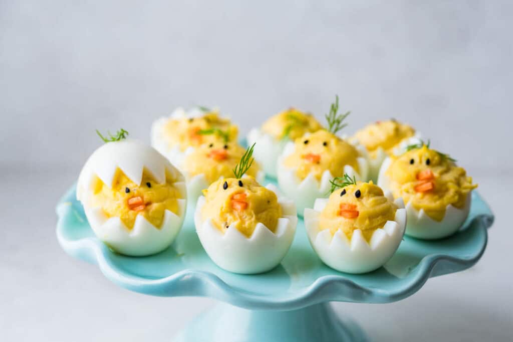 Serving a platter full of Easter deviled eggs decorated as baby chicks.