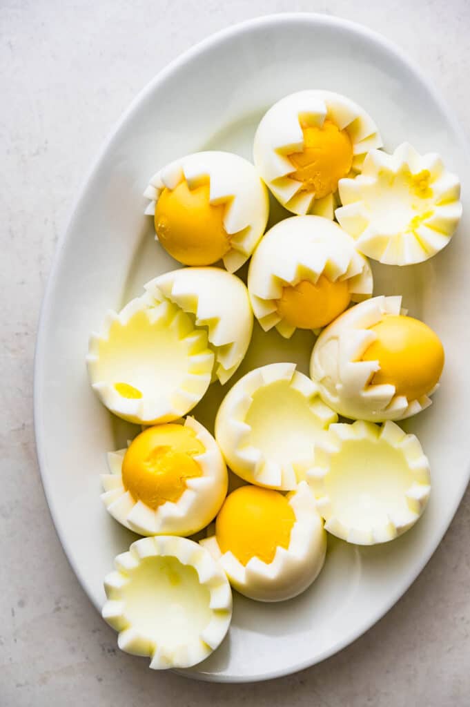 Perfectly cooked hard boiled eggs cut in Van Dyke fashion with whole yellow yolks.