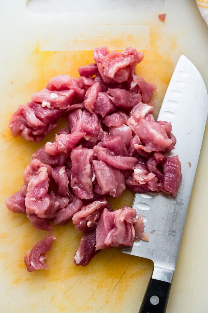 cutting pork tenderloin into bite sized bits.